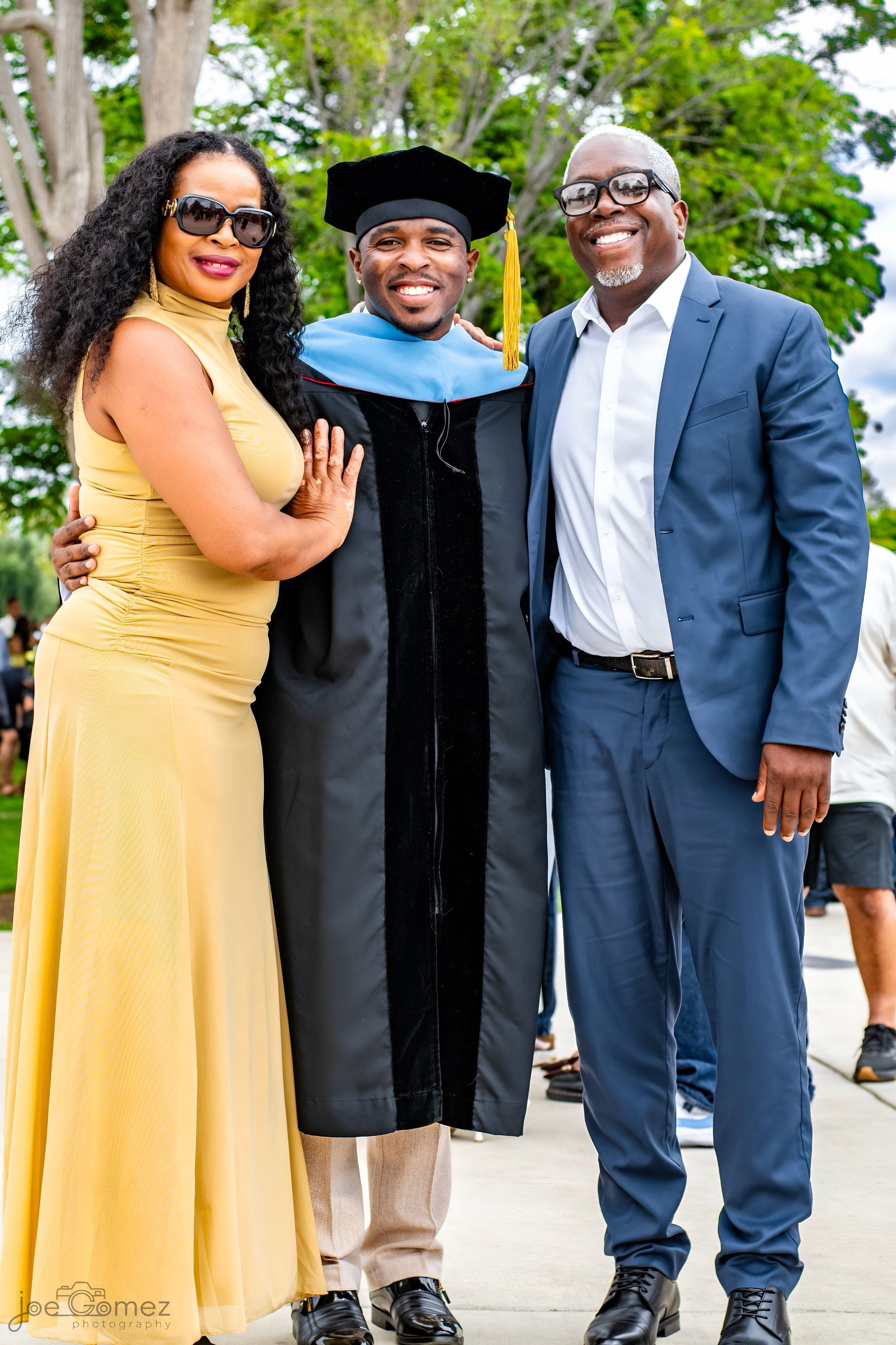 Graduate celebrating her doctorate with proud family members after a Southern California commencement ceremony.