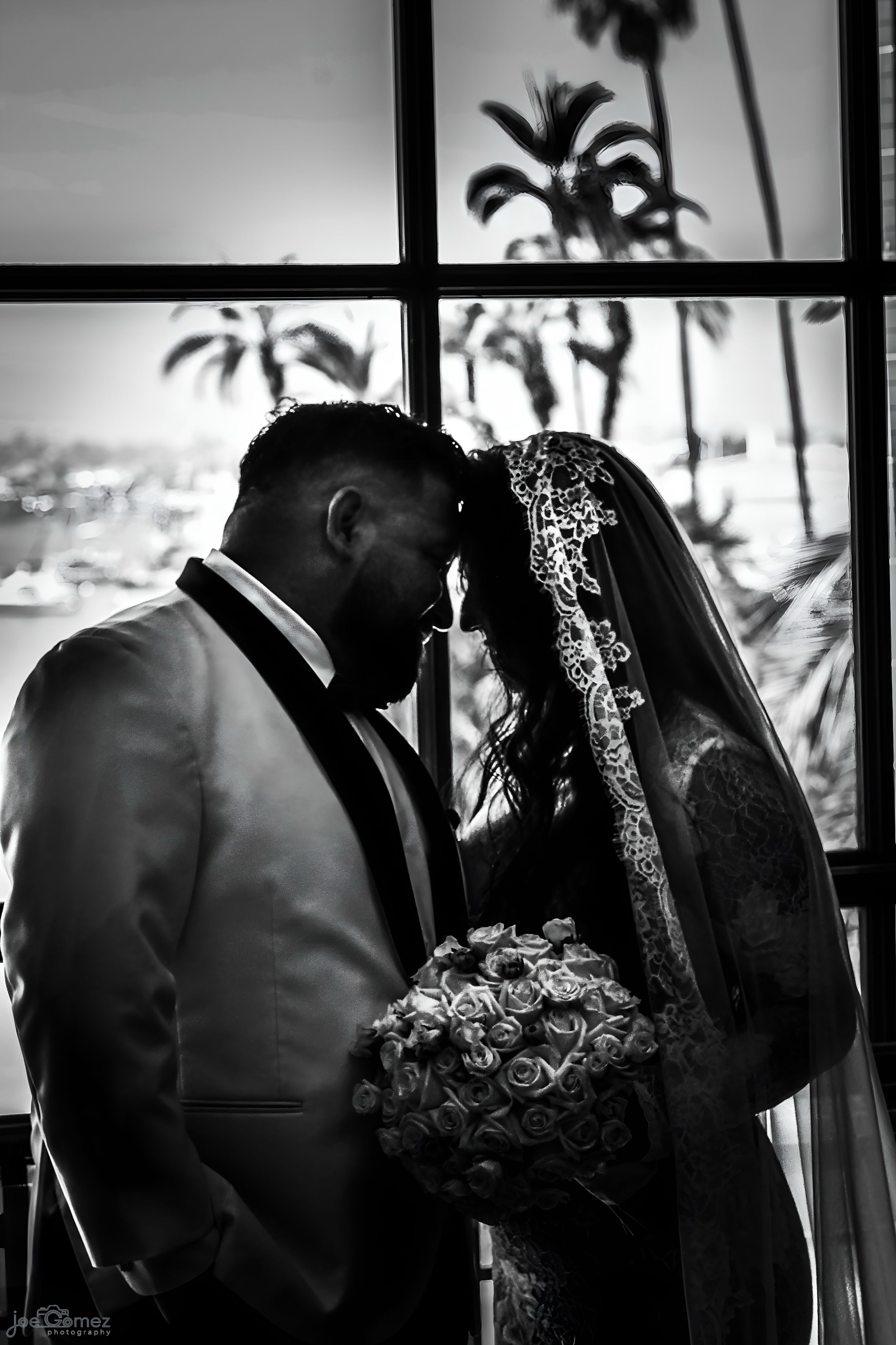 Black-and-white wedding portrait of a bride and groom sharing a quiet kiss, photographed in San Diego by Joe Gomez.
