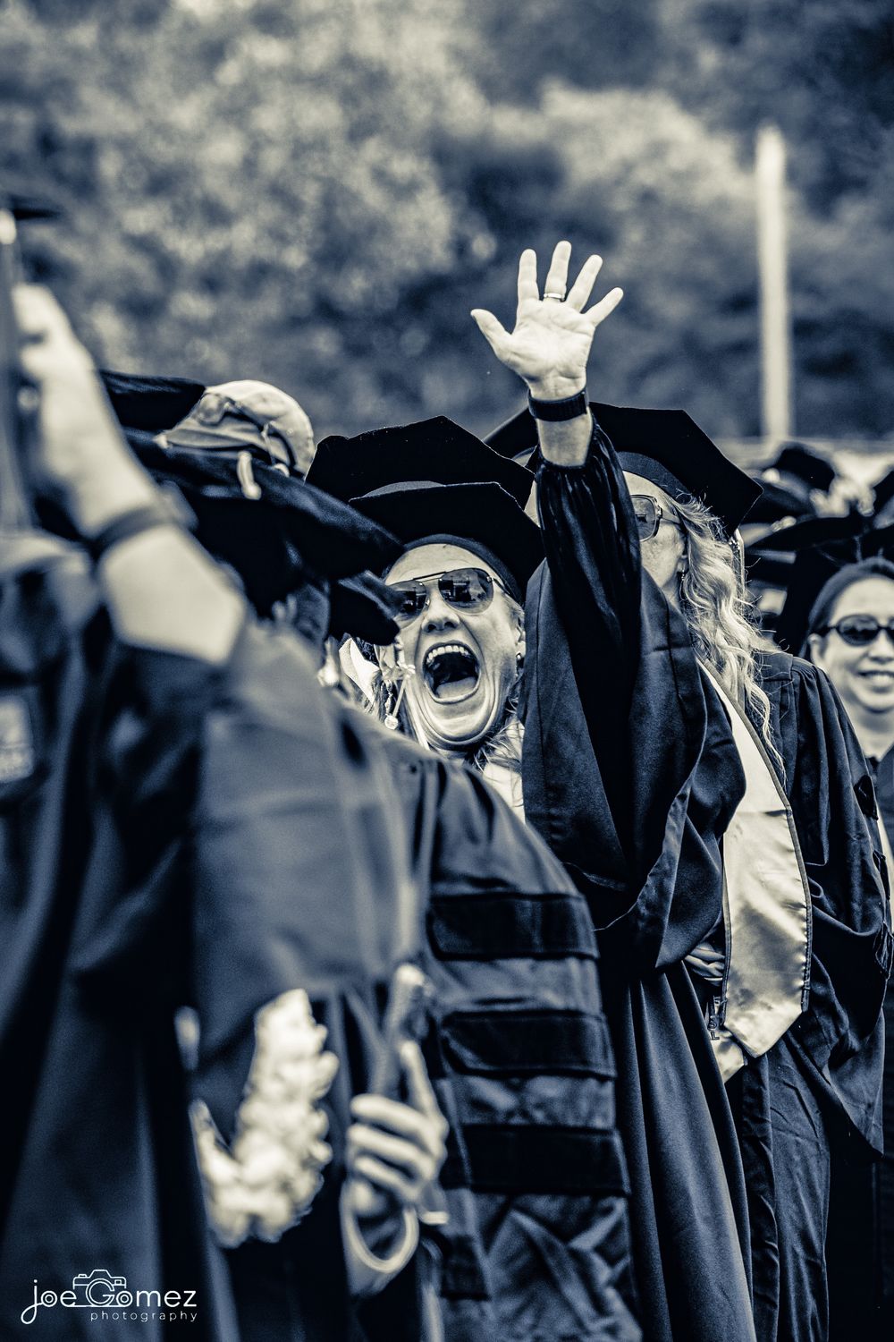 Candid graduation portrait of doctorate graduates cheering and celebrating their achievement in Irvine, California.